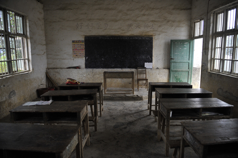 破旧的课桌和晕暗的教室。