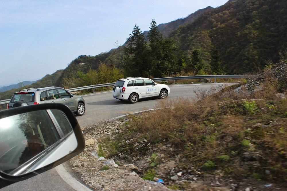 车队行驶在崎岖的山路上。